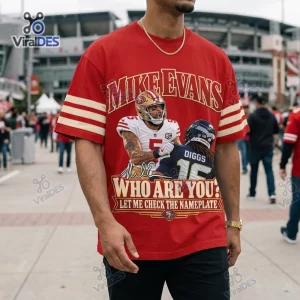 Front view of a red short-sleeve shirt with football graphics and text.