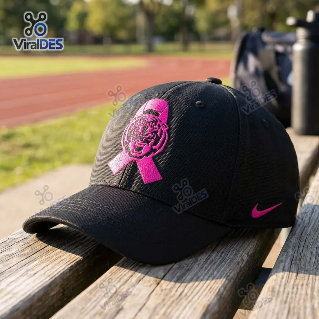 LSU Tigers Breast Cancer Awareness Baseball Cap resting on an outdoor bleachers bench near a running track showing the pink ribbon Tiger emblem