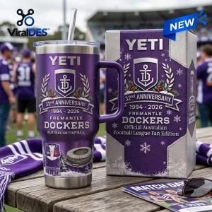Front view of a purple Fremantle Dockers 32nd Anniversary YETI Tumbler with straw and matching gift box on a wooden table.