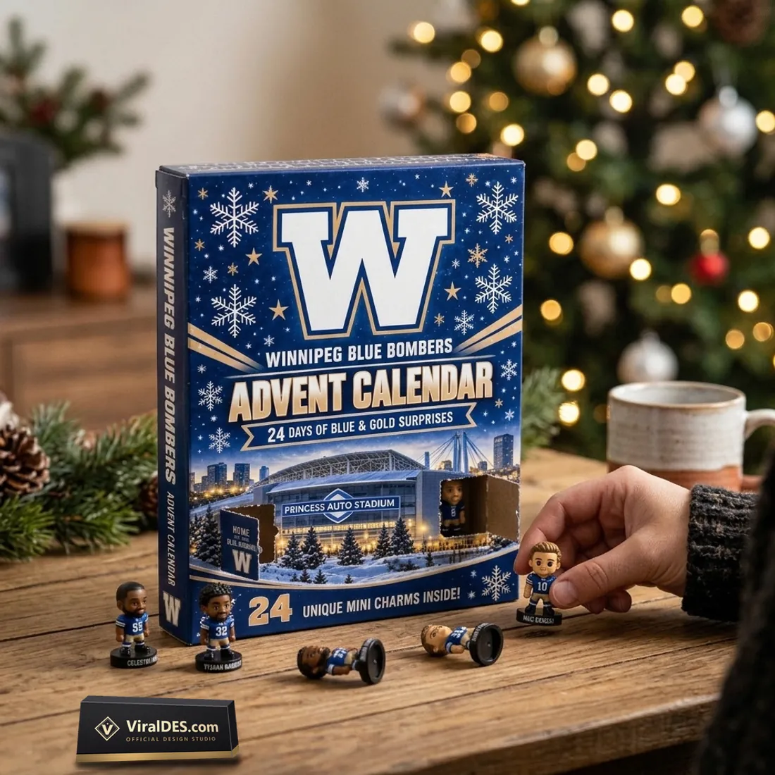 Winnipeg Blue Bombers Advent Calendar 2026 box with pre-scored compartment doors folded open as a hand places #10 Nic Demski on a wooden table