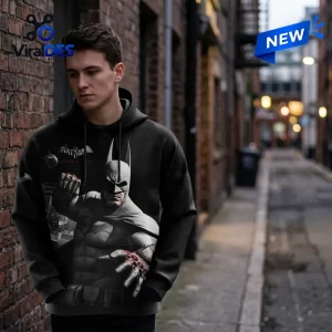 Man wearing a black Batman Arkham City 15th Anniversary hoodie in an alleyway.