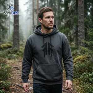 Man wearing a dark grey hoodie in a forest.