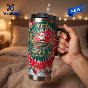 Hand holding a Yeti Santa Claus 253rd Anniversary Handle Tumbler with festive winter graphics.
