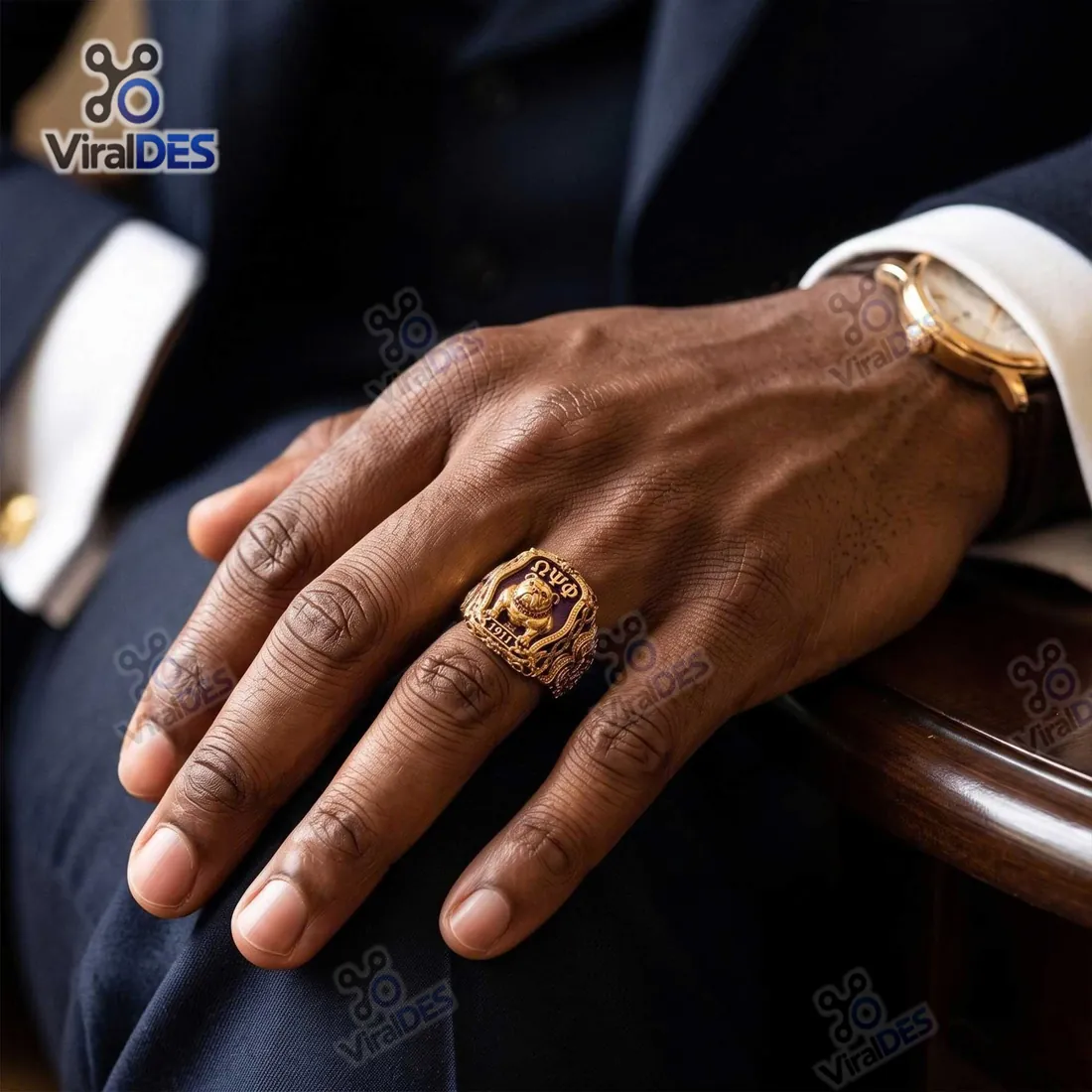 Omega Psi Phi Gold Bulldog Ring worn on the hand with a navy suit cuff and gold wristwatch