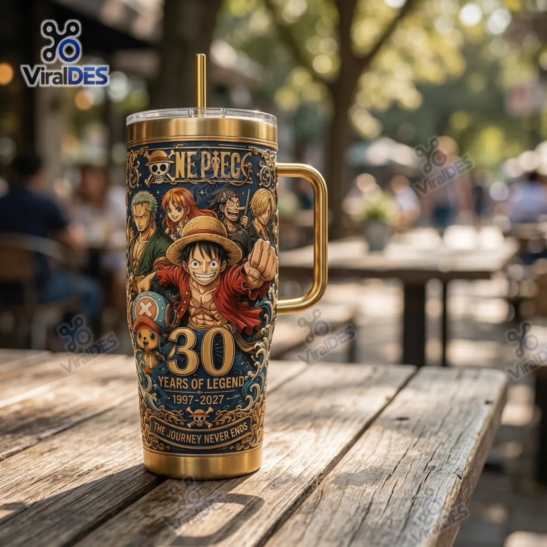 Outdoor sunlit view of the One Piece 30th Anniversary Gold Stanley Tumbler Cup showing the tapered cup-holder base and gold handle
