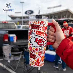 Hand holding a Kansas City Chiefs Football 40oz Tumbler Cup with red and white sticker graphics at a stadium parking lot.