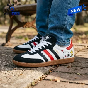 Lifestyle view of Snoopy x Woodstock Leather Samba Sneakers worn with blue jeans outdoors.