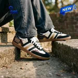 Lifestyle view of Greta Van Fleet Adidas Samba Sneakers worn on stone steps.
