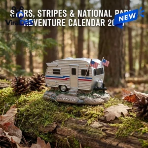 Close-up of a miniature vintage camper figurine with American flags resting on mossy ground in a forest.