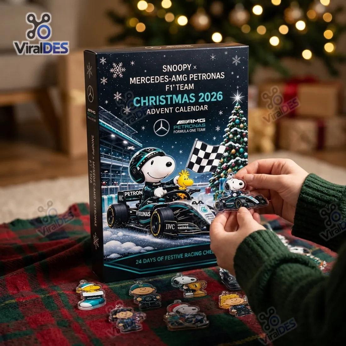 Hands holding the Day 5 Snoopy Mercedes-AMG F1 race car flat acrylic ornament in front of the Christmas 2026 Advent Calendar box
