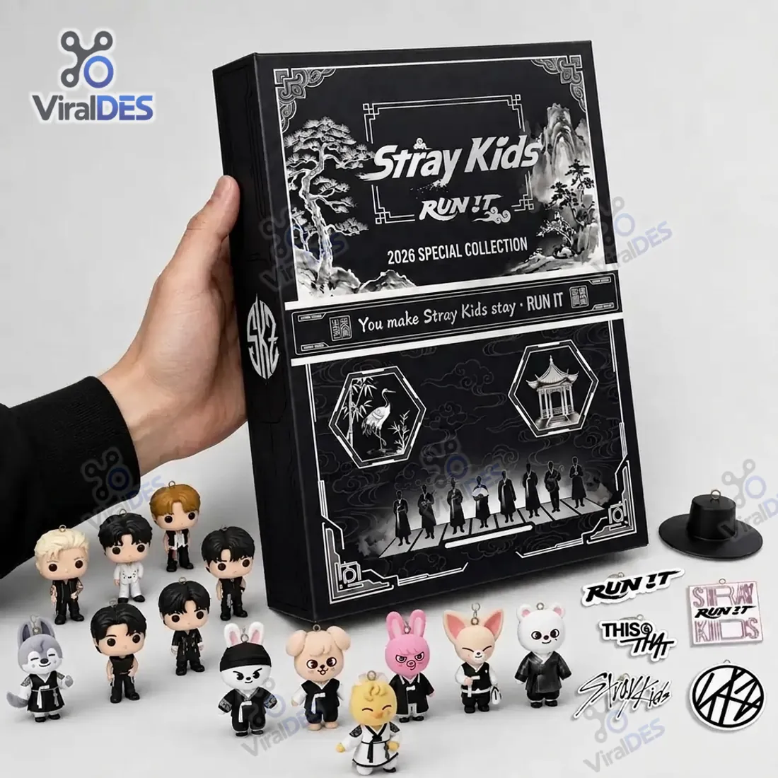 Hand holding Stray Kids 2026 Special Collection Advent Calendar next to 24 member, SKZOO, and RUN IT emblem charms