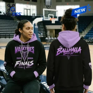 Two people wearing black and purple Golden State Valkyries 2026 Finals limited edition hoodies in an indoor basketball arena.