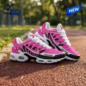 Side view of pink and white Breast Cancer Awareness Custom Name Air Max Plus Shoes on a running track.