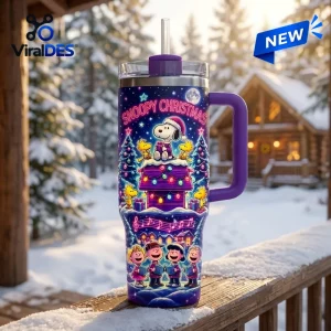 Front view of a purple Snoopy Christmas Winter Snow 40oz Tumbler on a snowy railing.