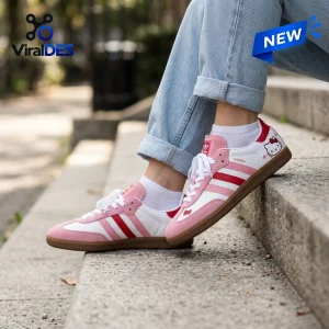 Side view of Hello Kitty Adidas Samba pink shoes worn with light blue jeans sitting on stone steps.