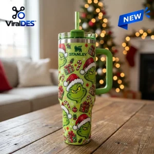 Front view of green holiday themed 40oz tumbler with festive character print on wooden table.