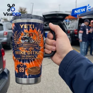 Hand holding a Mike Ditka Chicago Bears 87th Anniversary Tumbler with handle in outdoor parking setting.