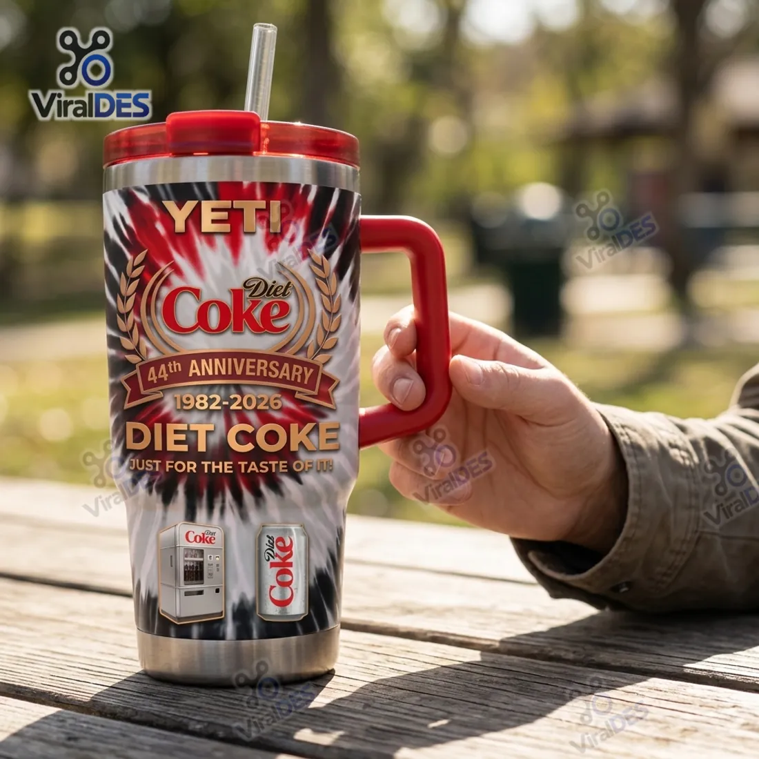 Hand gripping the crimson side handle of the YETI Diet Coke 44th Anniversary Tumbler outdoors