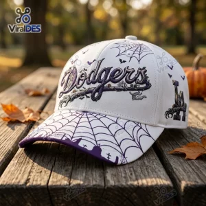 Front three-quarters view of the Los Angeles Dodgers Halloween baseball cap with purple spiderweb graphics on a wooden picnic table.